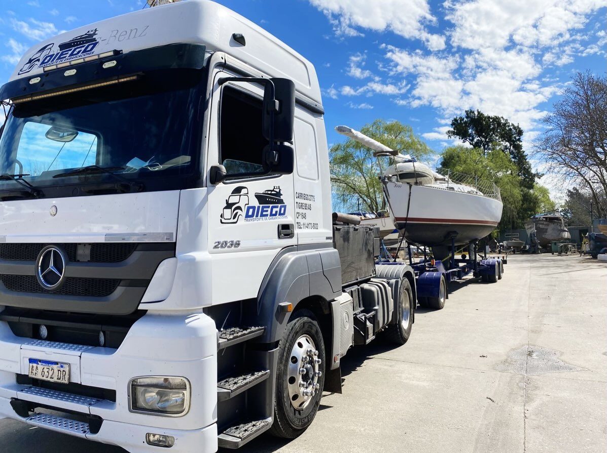 Mercedes Axor de Transporte Diego con un velero sobre el carretón, bajo un cielo azul