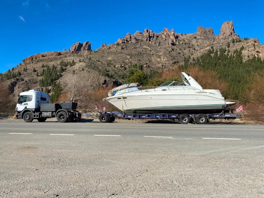Crucero sobre carretón detrás de un camión, en una ruta patagónica